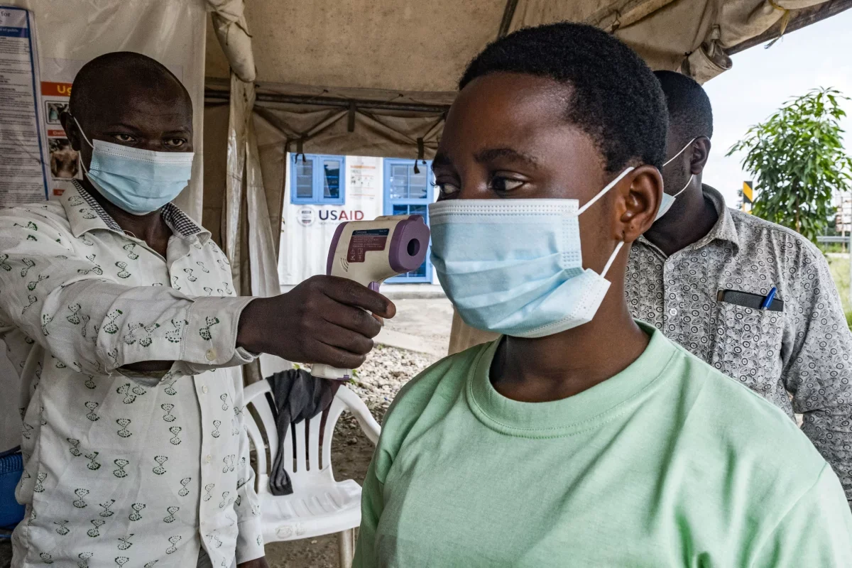 To keep Ebola from spreading in this current outbreak, a border health officer at the Busunga crossing between Uganda and the Democratic Republic of Congo checks a traveler's temperature using a contactless infrared thermometer on May 18.  Badru Katumba/AFP/via Getty Images