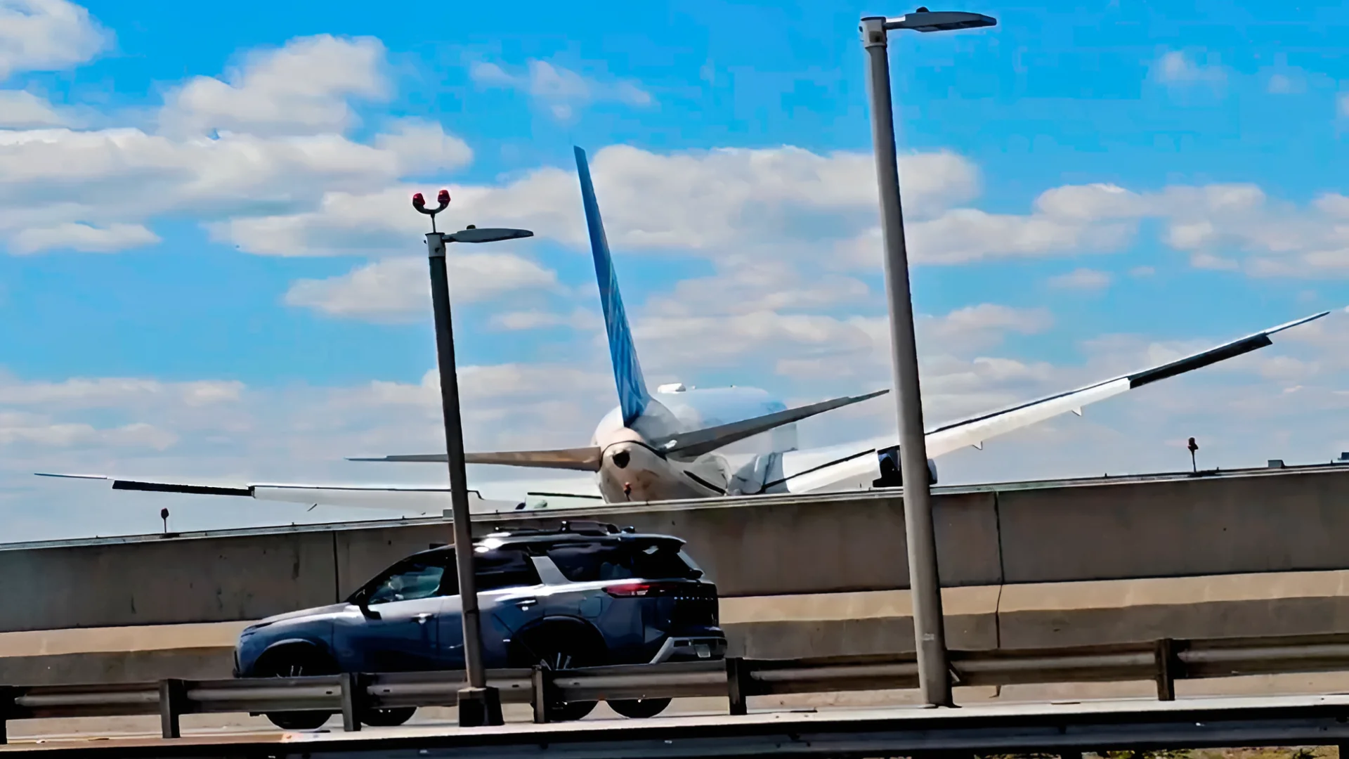 A United Airlines plane is seen in a still image taken from video after hitting a light pole on the New Jersey Turnpike as it lands at Newark Liberty International Airport, Sunday, May 3, 2026. (Patrick Oyulu, via AP)