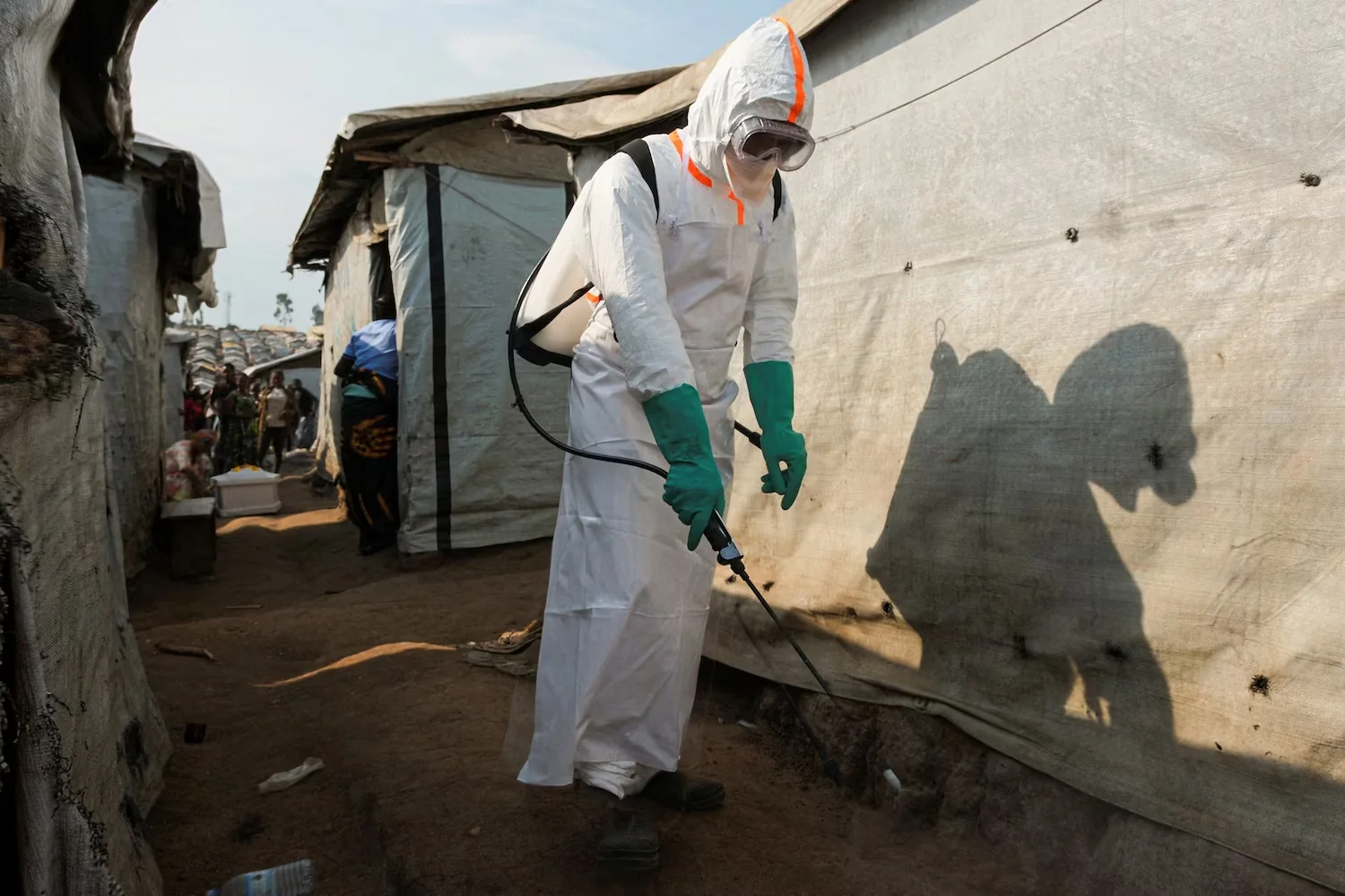 A health worker in full personal protective equipment (PPE) disinfects an area while preparing for the burial of suspected Ebola victims at the Kigonze displaced persons camp in Bunia, eastern Democratic Republic of Congo, on June 18, 2026. Gradel Muyisa Mumbere/Reuters