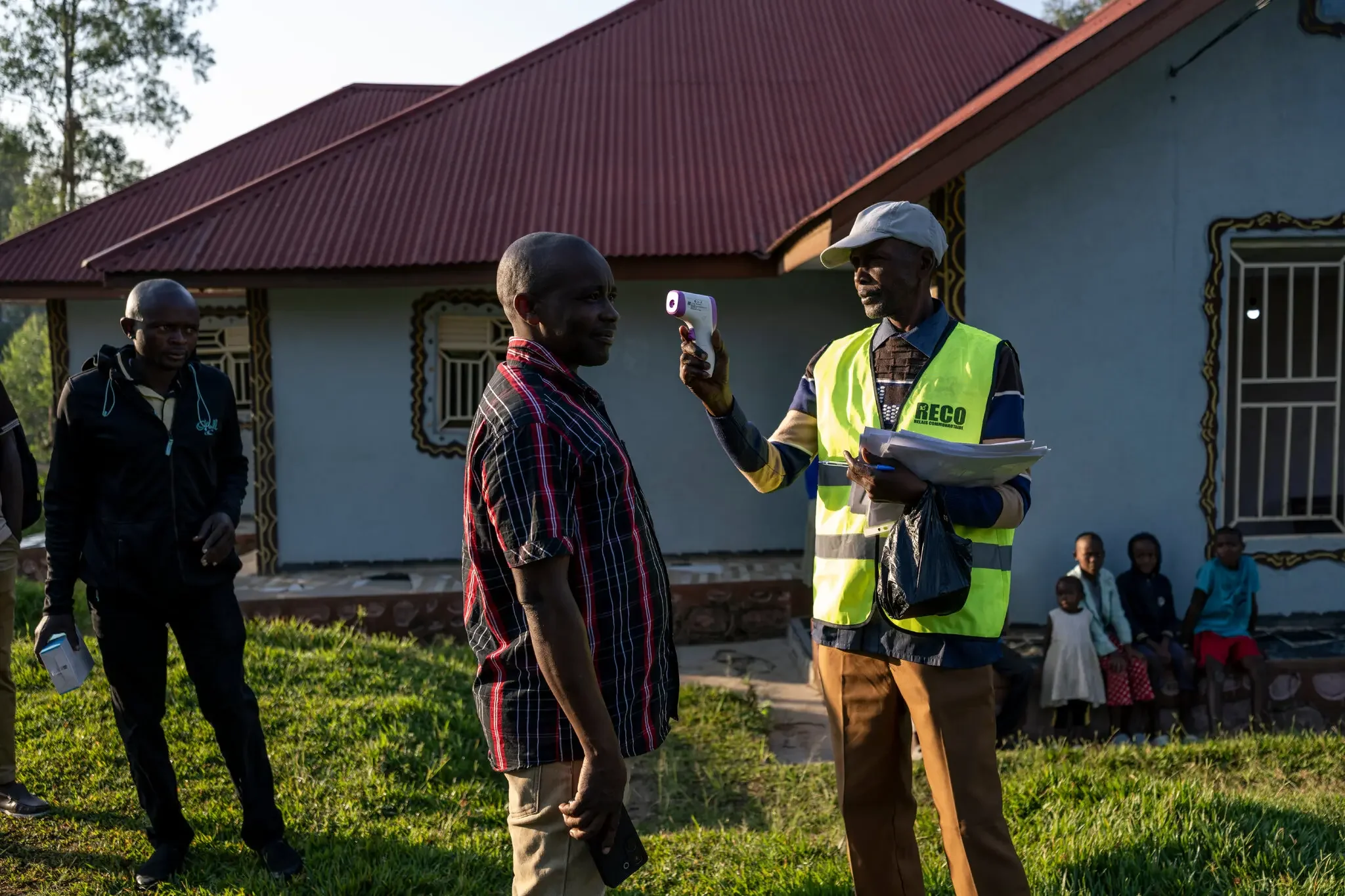 A community health worker taking the temperature of a man whose son is being treated for the virus near the city of Bunia in Democratic Republic of Congo. Credit: Arlette Bashizi for The New York Time