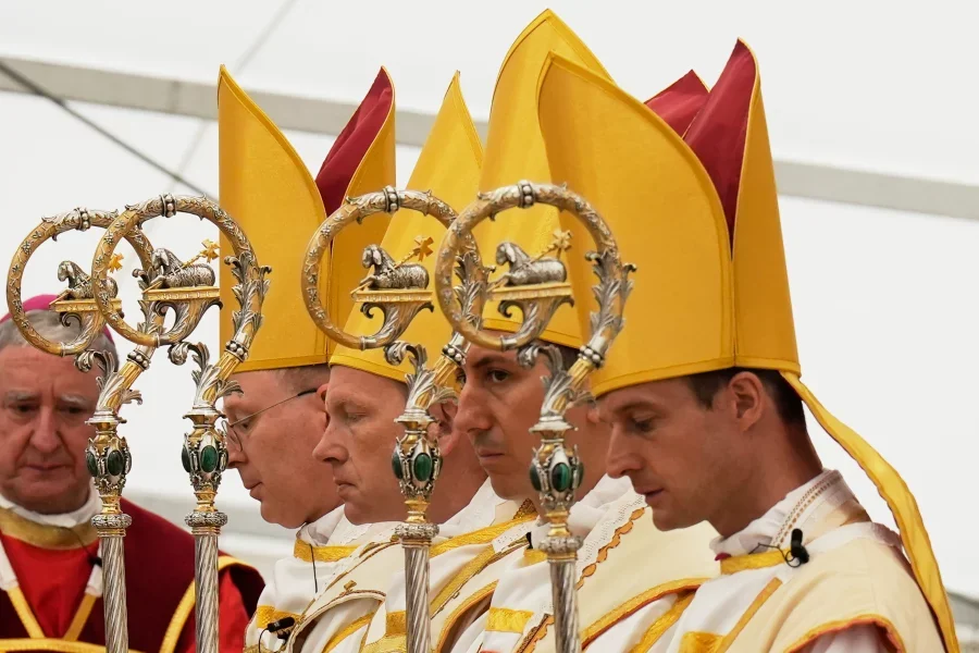 Newly consecrated Bishops, from left, Pascal Schreiber, Michael Goldade, Michel Poinsinet de Sivry and Marc Hanappier, wearing their miters and holding their pastoral staffs, pray at the end of their consecration ceremony in a tent set up outside the Society of St. Pius X seminary in Econe, Switzerland, Wednesday, July 1, 2026. Baz Ratner/AP