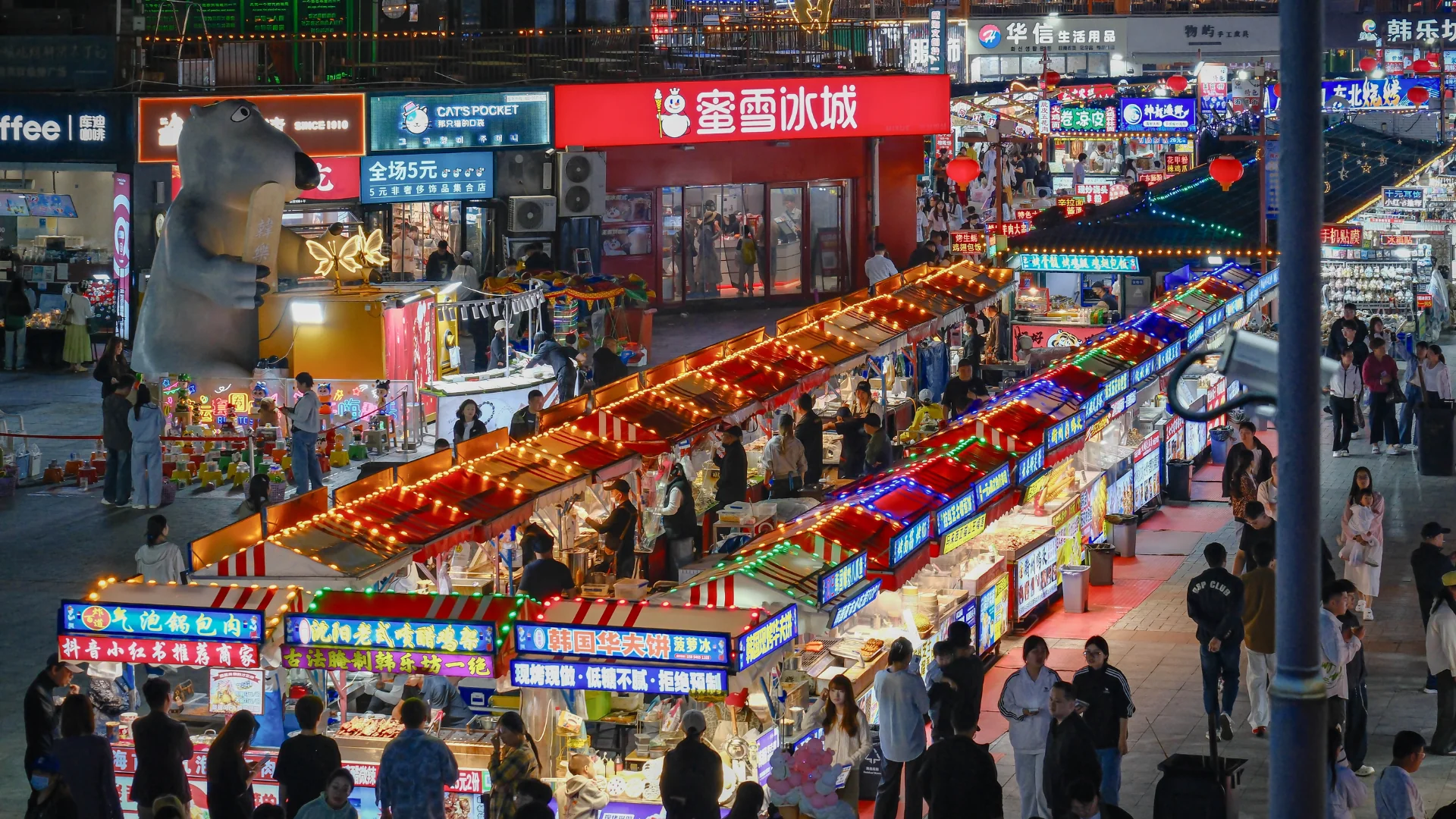 The colorful night market is bustling with people and food stalls, creating a vibrant atmosphere. Photo: BI ravencrow