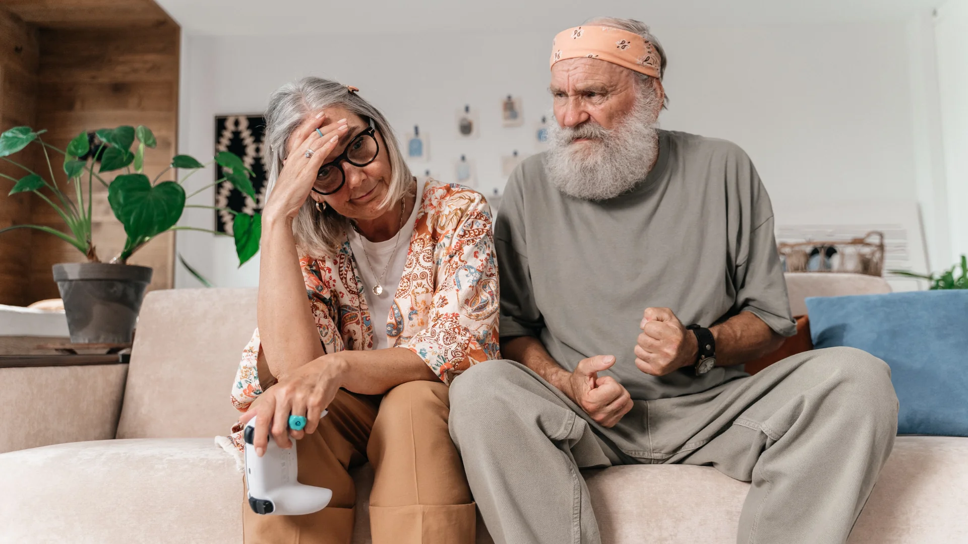 An elderly couple shows signs of frustration while sitting on the sofa at home. Photo: AI25.Studio